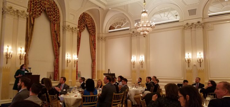 Members seated for dinner in an ornate ballroom